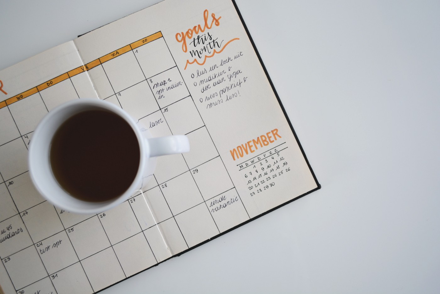 Coffeemug next to a calendar planner